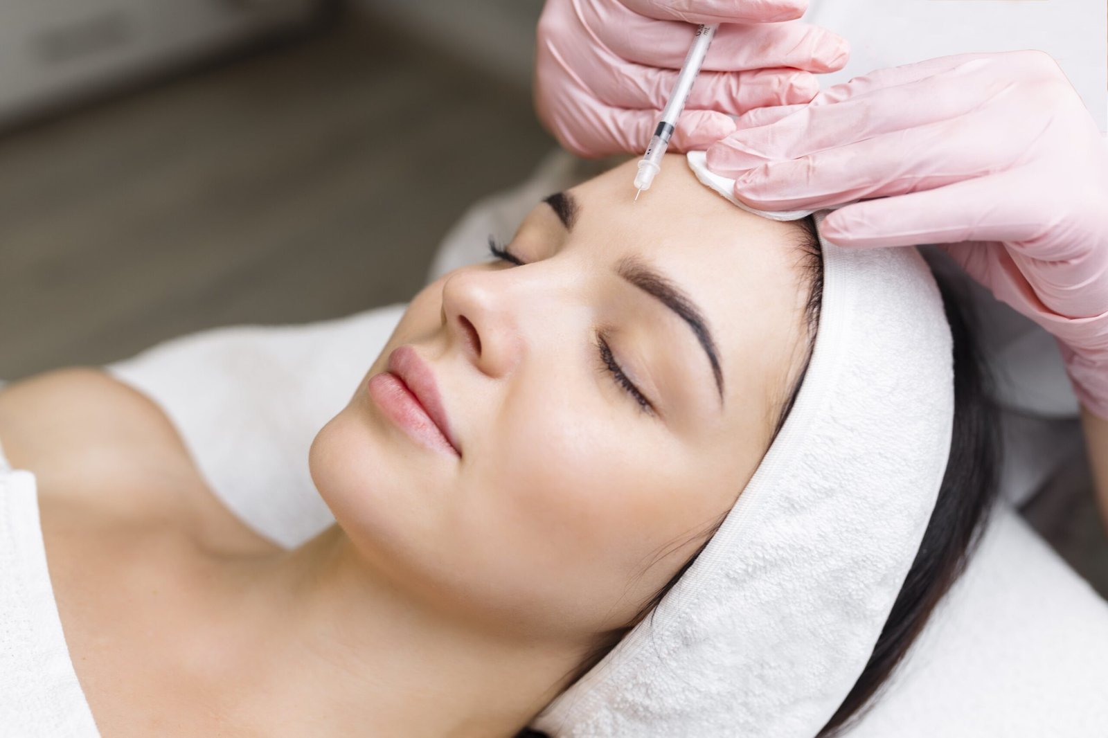 close-up-hands-young-cosmetologist-injecting-botox-female-face-she-is-standing-smiling-woman-is-closed-her-eyes-with-relaxation-min