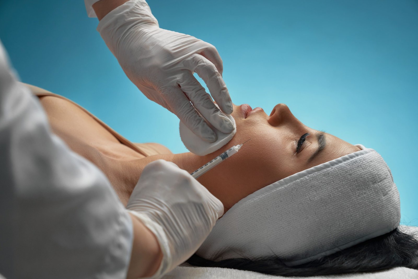 cosmetologist-using-syringe-correct-female-face-min