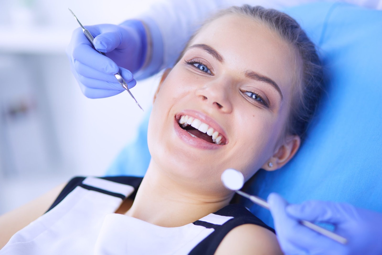 young-female-patient-with-open-mouth-examining-dental-inspection-dentist-office-min